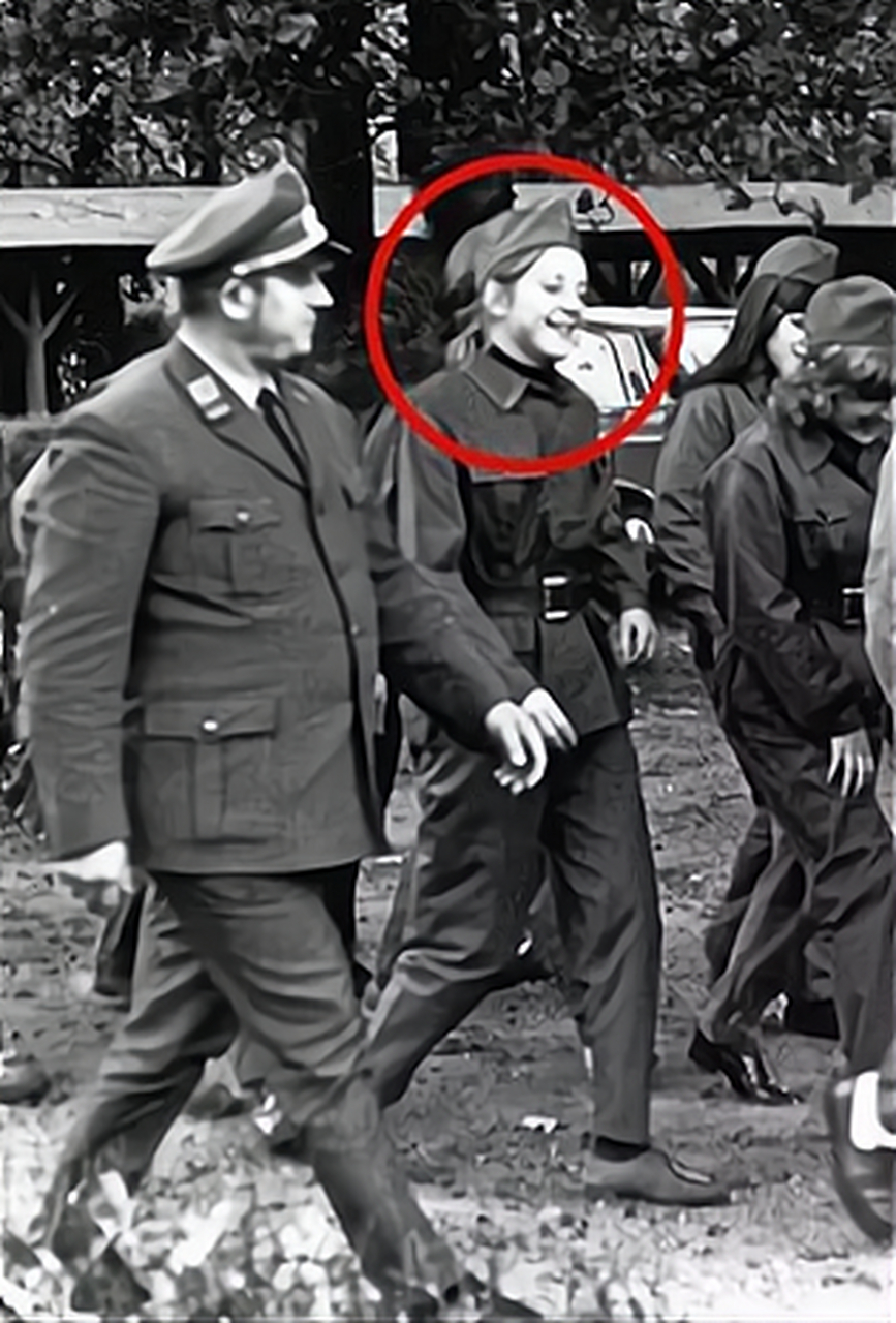 1971年,默克尔东德参加军训,穿着军装,戴着军帽,正和一起训练的军官在