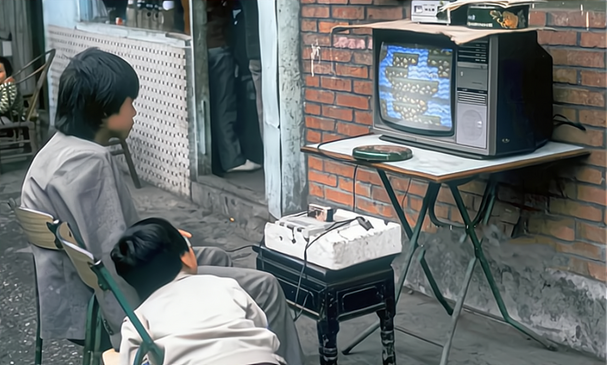 两兄弟坐在一台黑白电视机前打游戏,这是属于那个年代童年人的欢乐,看