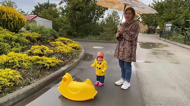 [图]萌到心坎里！小女孩在雨中跳舞，好像一只“小黄鸭”