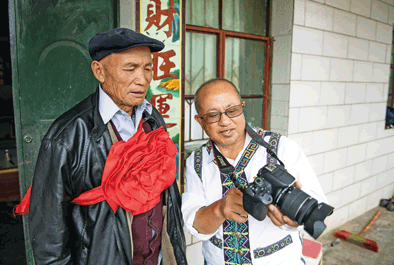 9月24日,高晓发(右)在与同村的马国祥老人分享所拍照片