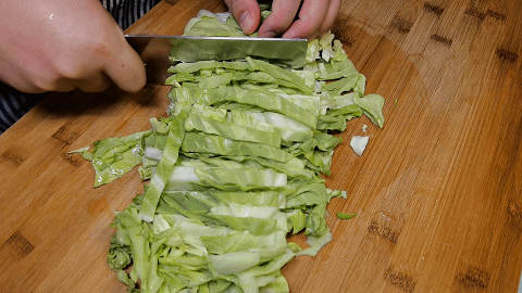 1包菜按照纹路掰下菜叶,用水冲洗干净后甩干水分,再把包菜切成长条
